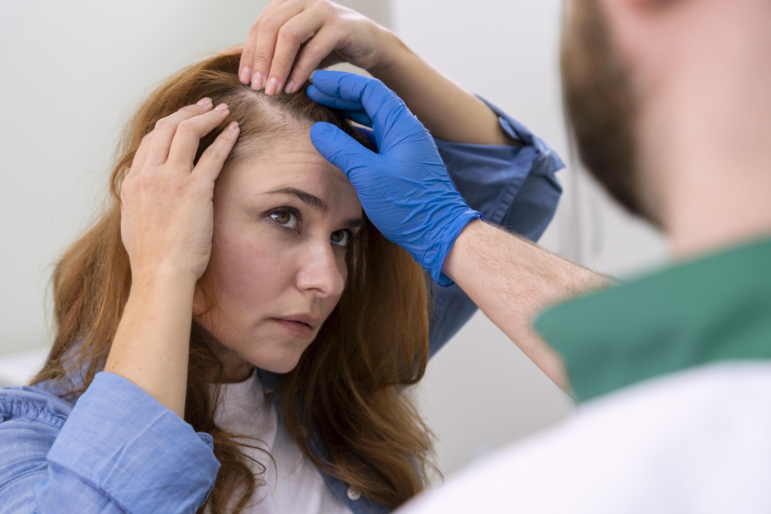 An Hair Transplant Specialist Inspecting Scalp and Receding Hairlines of an Older Woman