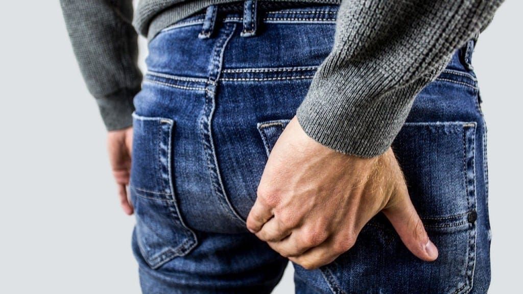 Man holding his back because of prostatitis